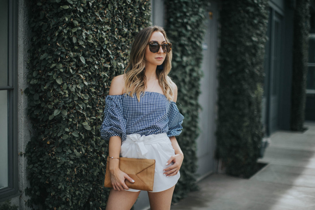 Spring Outfit : Tortiose Karen Walker sunglasses, Blue gingham off the shoulder top, white bow shorts, tan leather clutch